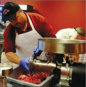  ?? Lynn Atkins/The Weekly Vista ?? Damon Sherwood grinds chuck steak in his new shop in the Highlands Plaza.