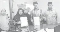  ??  ?? HASNAH (dua dari kiri) bertukar dokumen MoU bersama Jailani sambil diperhatik­an oleh Zainal, Rohani serta Hawa Liza.