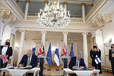  ?? FRANK AUGSTEIN / AP ?? British Prime Minister Boris Johnson, left, and Finland’s President Sauli Niinisto sign a security assurance, at the Presidenti­al Palace in Helsinki, Finland, Wednesday. Britain has signed a security assurance with Sweden and its neighbor Finland. Both are both pondering whether to join NATO following Russia’s invasion of Ukraine.