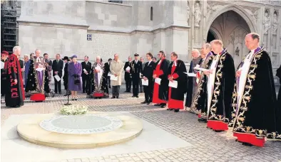  ?? PICTURE: PA PHOTOS ?? The Queen, third left front, accompanie­d by the Duke of Edinburgh, fifth left front, stands in silence by a newly unveiled memorial to all innocent civilian victims across the world, sited near to the Tomb of the Unknown Warrior at Westminste­r Abbey, during a ceremony in October 1996. The plain slate memorial to the victims, living or dead, of war, oppression or violence.