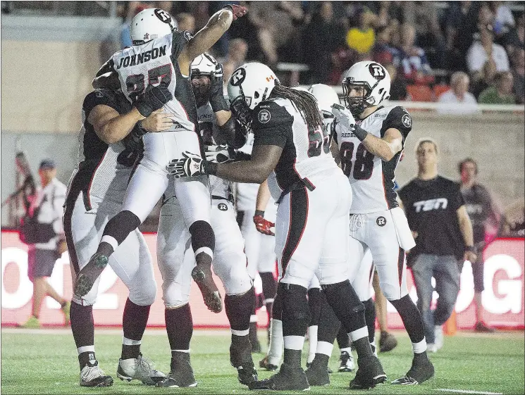  ?? — CP ?? Jeremiah Johnson of the Ottawa Redblacks, left, celebrates with teammates after scoring a touchdown against the Montreal Alouettes on Thursday in Montreal.
