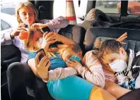  ?? JOHN LOCHER/ASSOCIATED PRESS ?? From left, Havyn Cargill-Morris, Dakota Keltner, Atryna Sweet and Timothy Keltner rest Friday in the back seat of a truck at an encampment outside a Walmart store for people displaced by the Camp Fire in Chico, Calif. The four from Magalia, Calif., escaped the fire with their families.