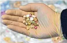  ?? Archivfoto: dpa ?? Ein Drogenfahn­der des Landeskrim­inalamtes zeigt eine Hand voll Ecstasypil­len.