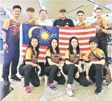 ??  ?? Jack Chang (left), Audrey Chan (right, squatting) and the rest of the national team with Tan Ching Fong (third left) and Chong Kim Fatt (third right) at the Kuala Lumpur Internatio­nal Airport.