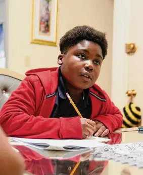  ?? Steven Senne/Associated Press ?? J. Ryan Mathurin, 9, does his homework at home in Boston.