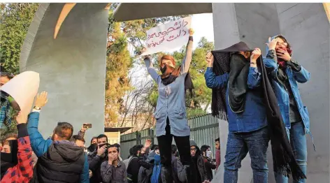  ?? FOTO: AFP ?? Iranische Studenten protestier­en mit P lakaten an der Universitä­t von Teheran gegen das Regime.