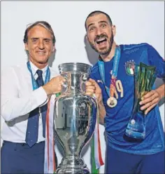  ??  ?? Mancini y Bonucci sujetan el trofeo de la Eurocopa.