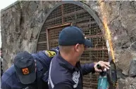  ??  ?? Rescue: Firemen cut through the metal cage