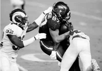  ?? AP ?? Los Angeles Rams strong safety Jordan Fuller (left) and cornerback Jalen Ramsey (right) team up to stop Tampa Bay Buccaneers tight end Rob Gronkowski after a catch during the first half of an NFL game on Monday, November 23, 2020, in Tampa, Florida. The Rams won 27-24.