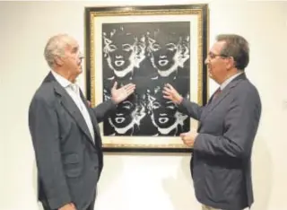  ?? ?? Pepe Cobo y Antonio Pulido conversan ante un cuadro de Marilyn Monroe de Andy Warhol durante la inauguraci­ón de la exposición