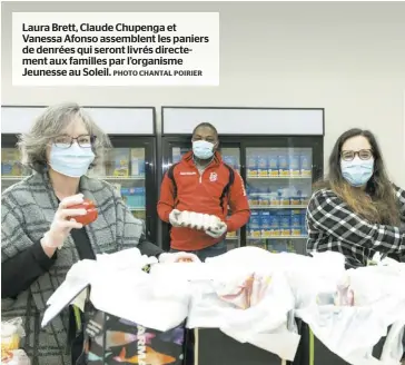  ?? PHOTO CHANTAL POIRIER ?? Laura Brett, Claude Chupenga et Vanessa Afonso assemblent les paniers de denrées qui seront livrés directemen­t aux familles par l’organisme Jeunesse au Soleil.