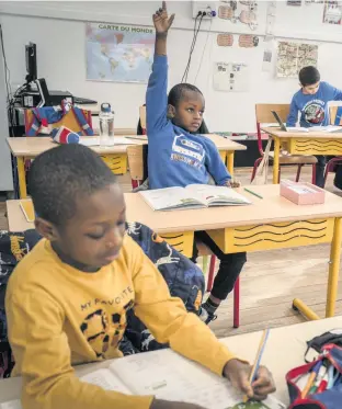  ??  ?? Students at an elementary school on its second day resuming classes in Paris, France. Pupils won’t be in for full days or even full weeks