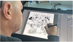  ?? FOTO: DPA ?? Zeichner Peral bei der Arbeit an einem Schlumpf-Comic.