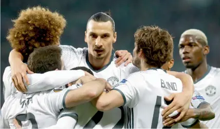  ?? — AP ?? Manchester United players celebrate team-mate Henrikh Mkhitaryan’s goal against Saint Etienne on Wednesday. United won 1-0.