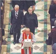  ?? [AP PHOTO] ?? Dennis and Judy Shepard hold hands as they walk behind Rev. V. Gene Robinson carrying their son’s ashes at the conclusion of a “Thanksgivi­ng and Remembranc­e of Matthew Shepard” service Friday at Washington National Cathedral in Washington.