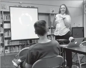  ?? Photo by Susan Holland ?? Katherine Auld, president of the Sugar Creek Astronomic­al Society, presented a program Aug. 3 at the Gravette Public Library on the upcoming Great American Eclipse. She explained how eclipses occur and went on to give details on the Great American...