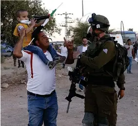  ??  ?? CONFLICTO. Un hombre palestino discute con soldados israelíes tras el arresto de su hijo, durante enfrentami­entos del frente para la Liberación Palestina, ayer 24 de junio. EFE