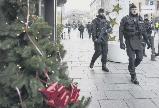  ??  ?? Armed police patrolling the area in Strasbourg around the Christmas market, which reopened yesterday following Tuesday’s attack which left three dead