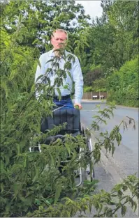  ??  ?? Pushing a wheelchair, James Flanagan finds his progress blocked by stinging nettles close to Bekesbourn­e station