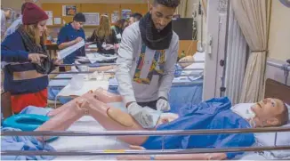  ?? MICHAËL MONNIER ARCHIVES LE DEVOIR ?? Des apprentis infirmiers s’exerçant sur un mannequin au cégep du Vieux Montréal en 2014