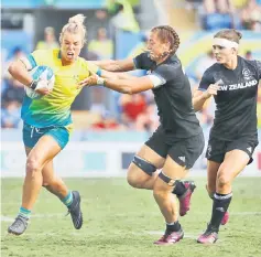  ?? — Reuters photo ?? Niall Williams of New Zealand (centre) and Emma Tonegato of Australia in action during the Gold Coast Commonweal­th Games rugby seven women’s gold medal match at Robina Stadium in Gold Coast, Australia in this April 15 file photo.