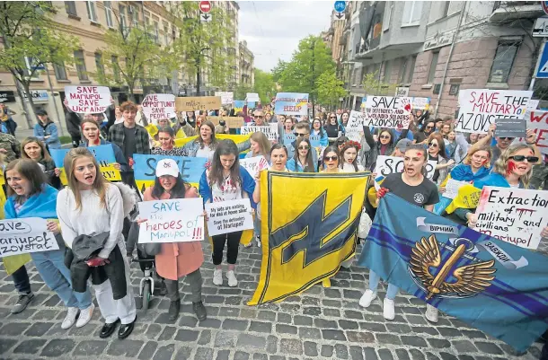  ?? ?? UNDER ATTACK: Wives of servicemen in the Azov Regiment with relatives and activists take part in a “Save the military of Mariupol” rally in Kyiv.