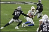  ?? ISAAC BREKKEN — THE ASSOCIATED PRESS ?? Chargers quarterbac­k Justin Herbert runs against Las Vegas Raiders outside linebacker Cory Littleton ( 42) during the second half on Dec. 17, in Las Vegas.