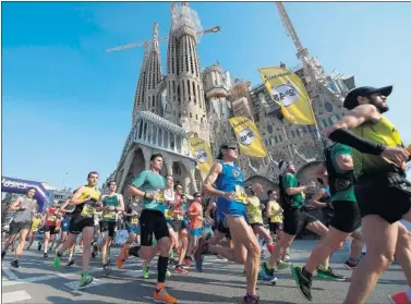  ??  ?? Los corredores de la maratón de Barcelona pasan por delante de la Sagrada Familia en 2019.