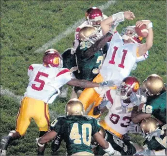  ?? Joe Raymond Associated Press ?? USC QUARTERBAC­K Matt Leinart (11), with a little help from Reggie Bush (5), scores the winning touchdown against Notre Dame with three seconds left in the 2005 indelible game at South Bend, Ind.