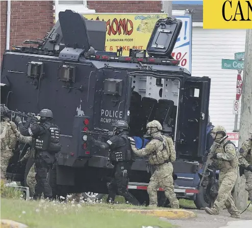  ?? ANDREW VAUGHAN / THE CANADIAN PRESS FILES ?? Emergency response officers enter a residence in Moncton, N.B., in 2014 during a manhunt for Justin Bourque, after he shot and killed three officers and wounded several others in a daytime attack on the police.