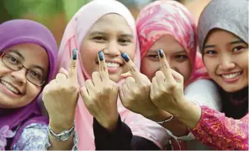  ?? FILE PIC ?? Women showing their fingers marked with indelible ink after voting in Bangi in the 13th General Election. Three-cornered fights involving Umno, Pas and Parti Amanah Negara are expected to favour Umno.