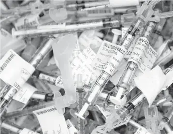  ?? TED S. WARREN/AP ?? Spent COVID-19 vaccinatio­n syringes used to give the Pfizer vaccine are shown Tuesday at the VA Puget Sound Health Care System campus in Seattle. States are racing to make up for last week’s lack of progress caused by storms.