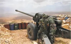  ?? Hussein Malla / Associated Press 2016 ?? Lebanese army soldiers fire a 130mm howitzer cannon last year at areas controlled by Islamic State fighters near Arsal, in northeast Lebanon.
