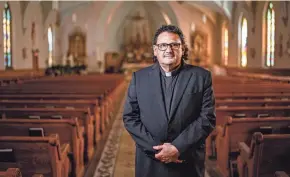  ?? ZACH BOYDEN-HOLMES/DES MOINES REGISTER ?? The Rev. Nils Hernandez stands in the Queen of Peace Catholic Church in Waterloo, Iowa. An immigrant himself, “I feel the pain and the concerns that my brothers and sisters have,” he said.