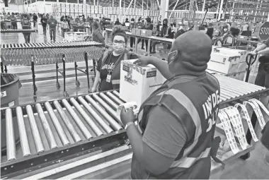  ?? POOL PHOTO BY TIMOTHY D. EASLEY ?? The first box containing the Johnson & Johnson COVID-19 vaccine heads down the conveyor to a waiting transport truck at the McKesson facility in Shepherdsv­ille, Ky., on March 1.