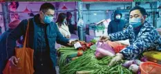  ?? Foto: dpa ?? Schon vor einem Jahr schützten sich die Menschen in Wuhan mit Masken. Experten gehen nun auf Suche nach dem Ursprung des Coronaviru­s.