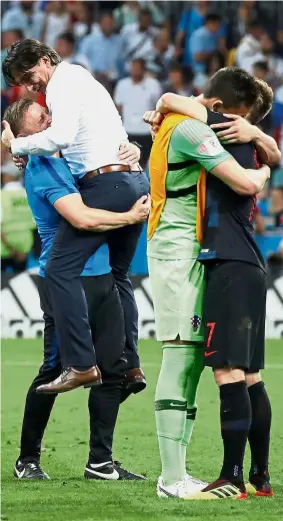  ??  ?? We did it!: Croatia coach Zlatko Dalic (in white) celebratin­g with Ivica Olic as Ivan Rakitic (second from right) hugs Dominik Livakovic after beating Russia in the quarter-finals on Saturday.