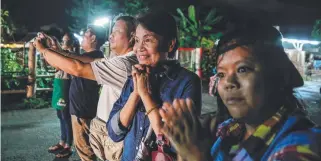  ?? Picture: GETTY ?? Onlookers watch and cheer as the rescued boys are ferried to hospital.