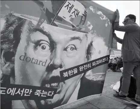  ??  ?? Anti-war activists hold a banner showing a caricature of US President Donald Trump during an anti-Trump rally near the US embassy in Seoul on Wednesday. The Korean script on the banner reads, “If war breaks out, only those on the Korean Peninsula will...