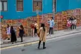  ??  ?? This picture shows a woman (center) standing on the road as she takes a photo at a popular Instagram spot in Hong Kong. — AFP photos