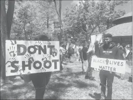  ??  ?? Protesters hold signs urging an end to police violence against black people at a rally Saturday in Bushnell Park in Hartford, joining similar movements across the country.