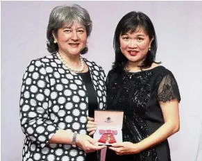  ??  ?? What an honour: Treadell (left) giving the award to Teo for her services to medical research during the award ceremony in Kuala Lumpur.