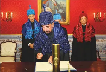  ??  ?? WAM Dr Shaikh Sultan signs the visitors’ book following a tour of the University of Coimbra in Lisbon.