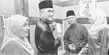  ??  ?? NEW CHIEF MINISTER: Mohd Ali (second left) shows his clock in/out card to his successor Idris Haron at the Chief Minister’s Office in Melaka. Also seen are Mohd Ali’s wife Datin Seri Asmah Abdul Rahman (left) and Idris’ wife Datin Fadilah Abdullah...