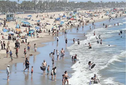  ??  ?? Visitors crowd a beach in Santa Monica, Calif., Sunday despite the ongoing coronaviru­s pandemic.