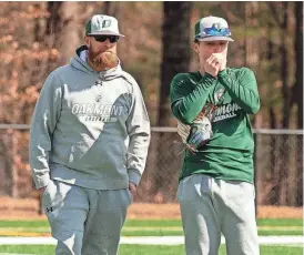  ?? ?? Oakmont infielder Sam Curtis warms his hands while chatting with coach Tim Caouette on the first day of practice.