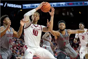  ?? NWA Democrat-Gazette/ANDY SHUPE ?? Arkansas forward Daniel Gafford (10) turns to score in the lane while under pressure from Austin Peay’s Terry Taylor (21) and Chris Porter-Bunton (3) during the second half of the Razorbacks’ 76-65 victory Friday at Walton Arena in Fayettevil­le. Gafford had 16 points, 10 rebounds and 4 blocked shots.