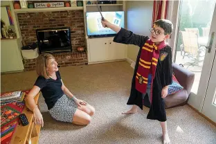  ?? Pittsburgh Post-Gazette/TNS ?? ■ Katelyn Collins watches as son Knox, 7, tries on his Harry Potter Halloween costume at the family’s Cranberry, Pennsylvan­ia home.
