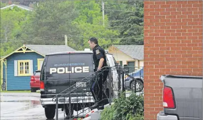  ?? COLIN MACLEAN/TC MEDIA ?? A Summerside Police officer exits the Summerside Motel & Cottages in Summerside. Someone in a black mask robbed the establishm­ent Thursday morning. It was one of two motels targeted by thieves on Thursday.