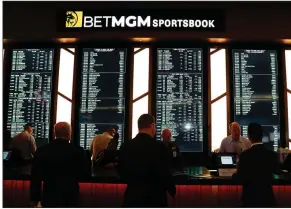  ?? (AP/Paul Sancya) ?? Employees work at the MGM Grand Detroit casino sports book in March. Sports bettors are sitting on a large amount of money as the coronaviru­s has shut down major sports leagues, and analysts say some of those gamblers are turning to the stock market.